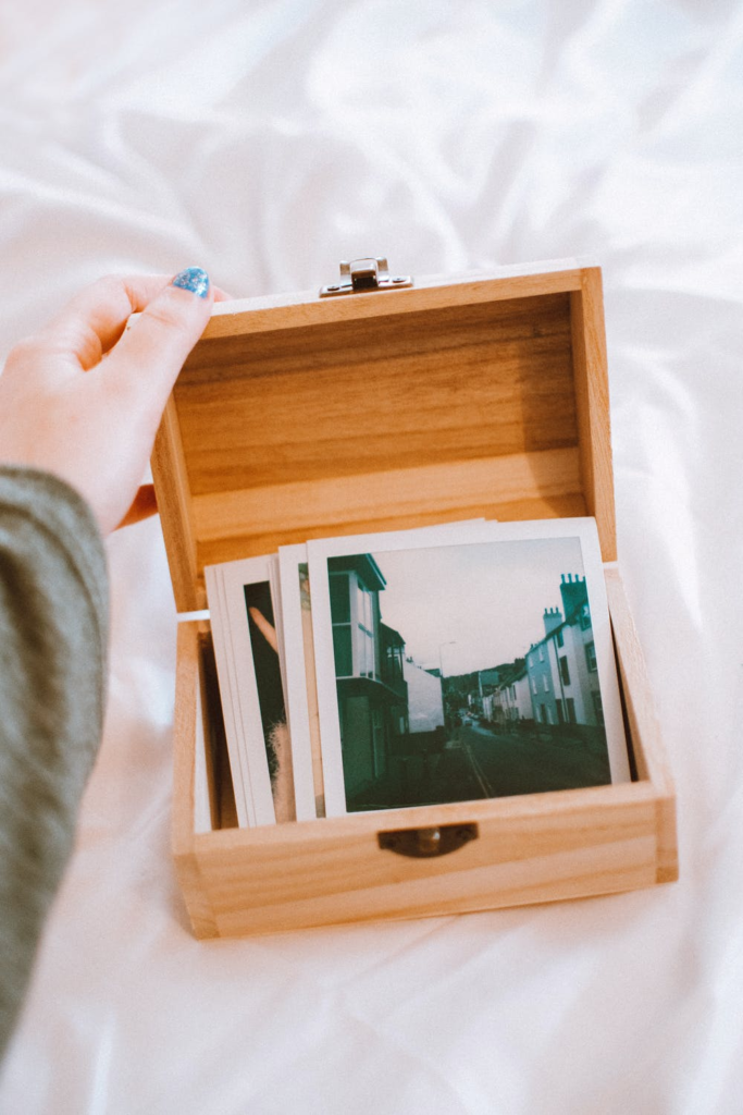 wooden box open with old polaroids inside.