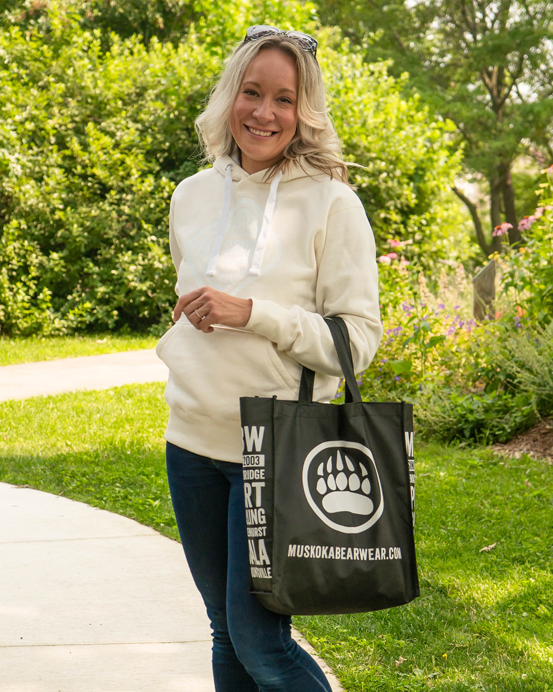 Product Shot of woman wearing a Ivory White Hoody with a white Muskoka Bear Wear logo on the frnot.